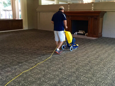 Technician operating a yellow and blue Cimex CR48 carpet cleaning machine