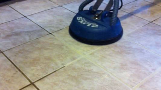 Tile cleaning machine in action on light-colored tiled floor, showcasing effective floor maintenance solution.