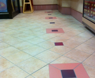 Tiles with a modern design featuring beige and pink colors in a commercial setting. Clean and well-maintained flooring.