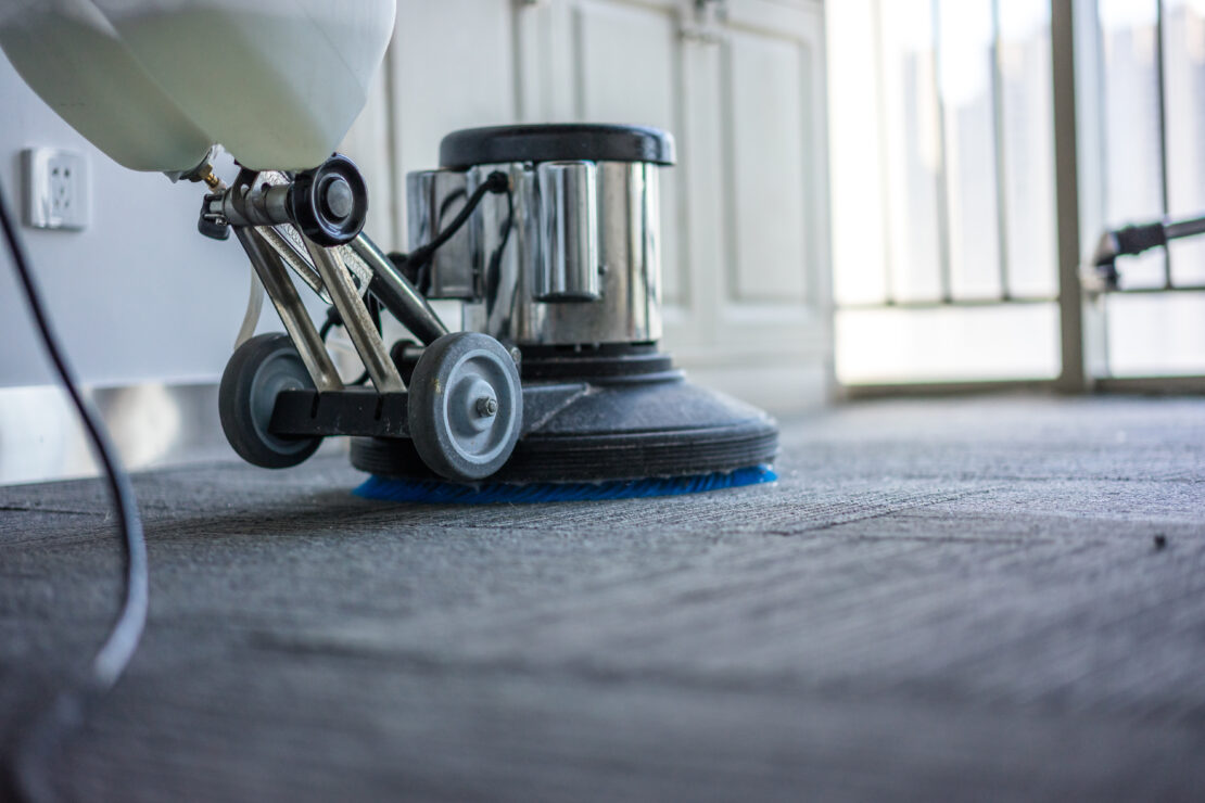 Carpet is being cleaned with a bonnet machine